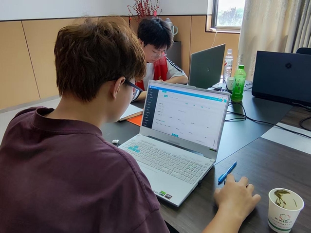 学生们和工作人员一起录入信息